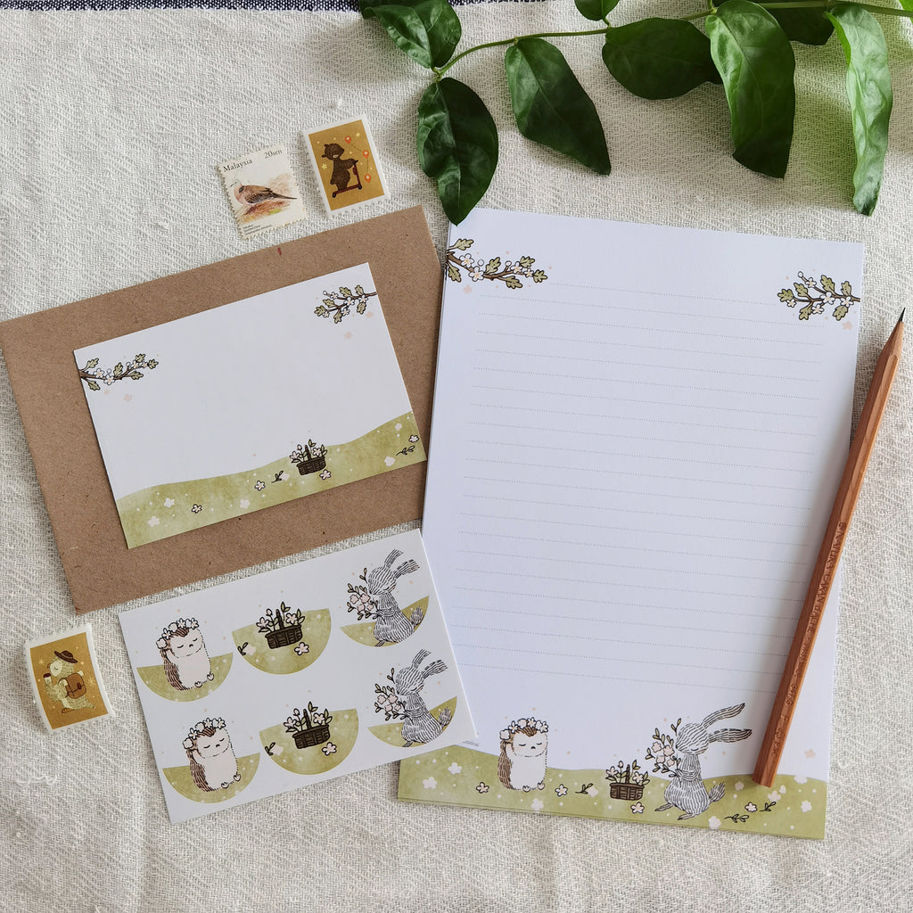 Summer Meadow Blooms Letter Writing Set - Immerse in a whimsical world as a rabbit and hedgehog create flower crowns on these delightful letter writing sheets, capturing the essence of summer.