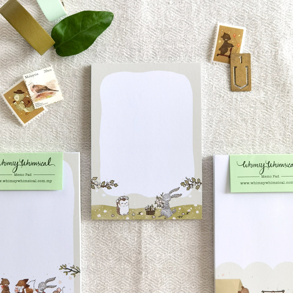 Summer Meadow Blooms Memo Pad feature whimsical rabbit & hedgehog crafting flower crowns in summer, perfect for notes & ideas.