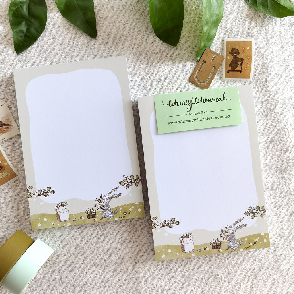 Summer Meadow Blooms Memo Pad feature whimsical rabbit & hedgehog crafting flower crowns in summer, perfect for notes & ideas.