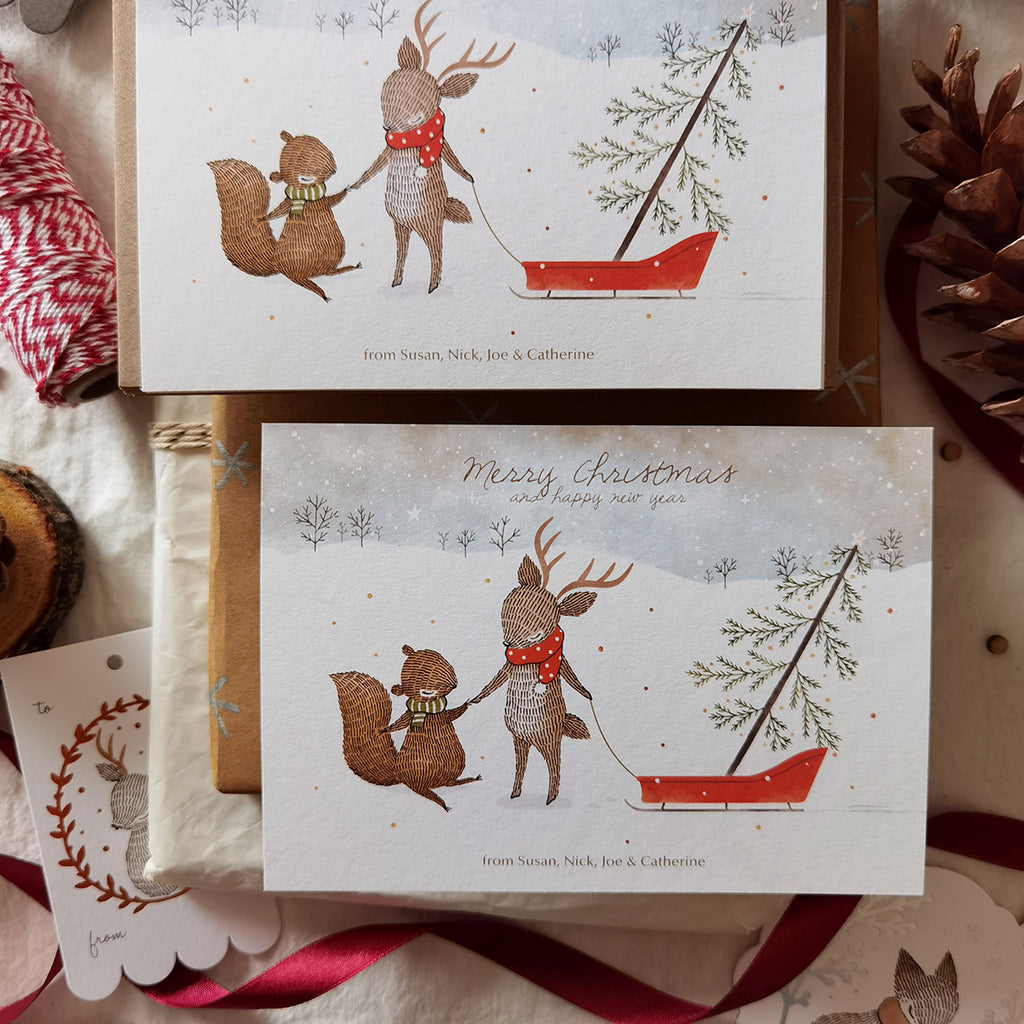 Illustrated notecards featuring squirrel & reindeer bringing home a pine tree, personalized names for holiday greetings.