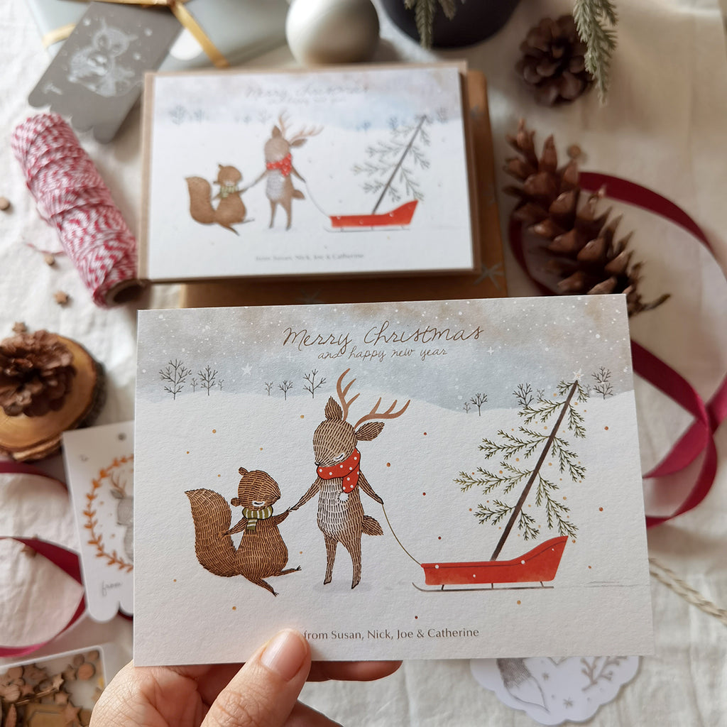 Illustrated notecards featuring squirrel & reindeer bringing home a pine tree, personalized names for holiday greetings.